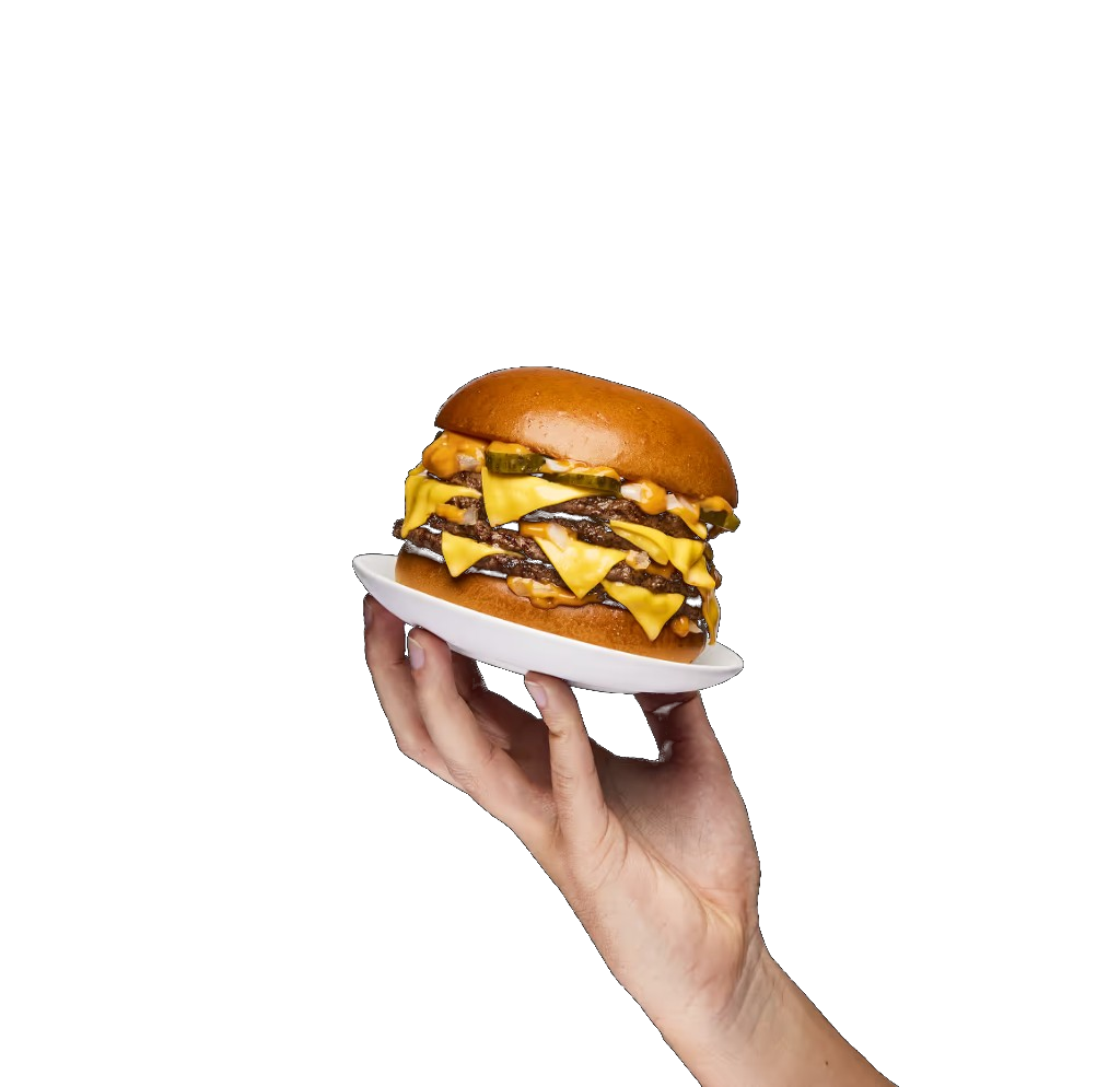 A freshly stacked cheeseburger held on a small plate